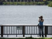 Jennifer Iverson of Vancouver takes advantage of the summery weather this week for photography on the Columbia River at Waterfront Park on Monday.