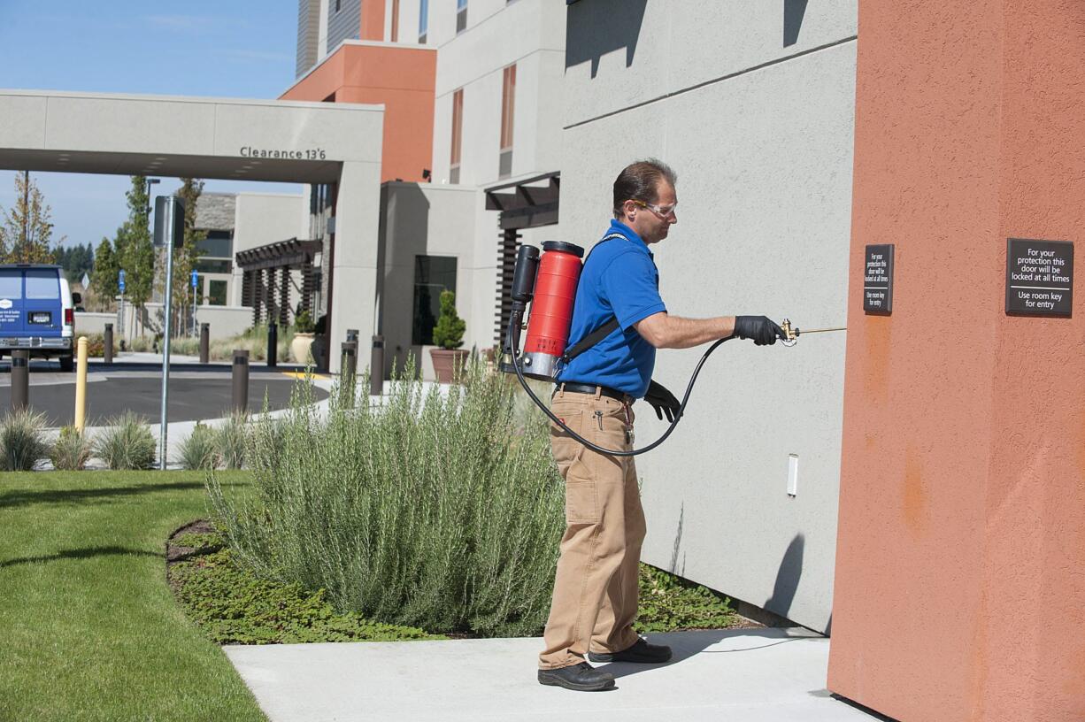 Wally Melendez, owner of A&amp; R Pest Solutions, performs a monthly perimeter service for general pests at the Hampton Inn &amp; Suites in Vancouver on Thursday.