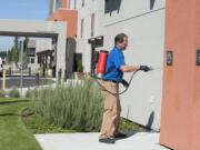 Wally Melendez, owner of A&amp; R Pest Solutions, performs a monthly perimeter service for general pests at the Hampton Inn &amp; Suites in Vancouver on Thursday.