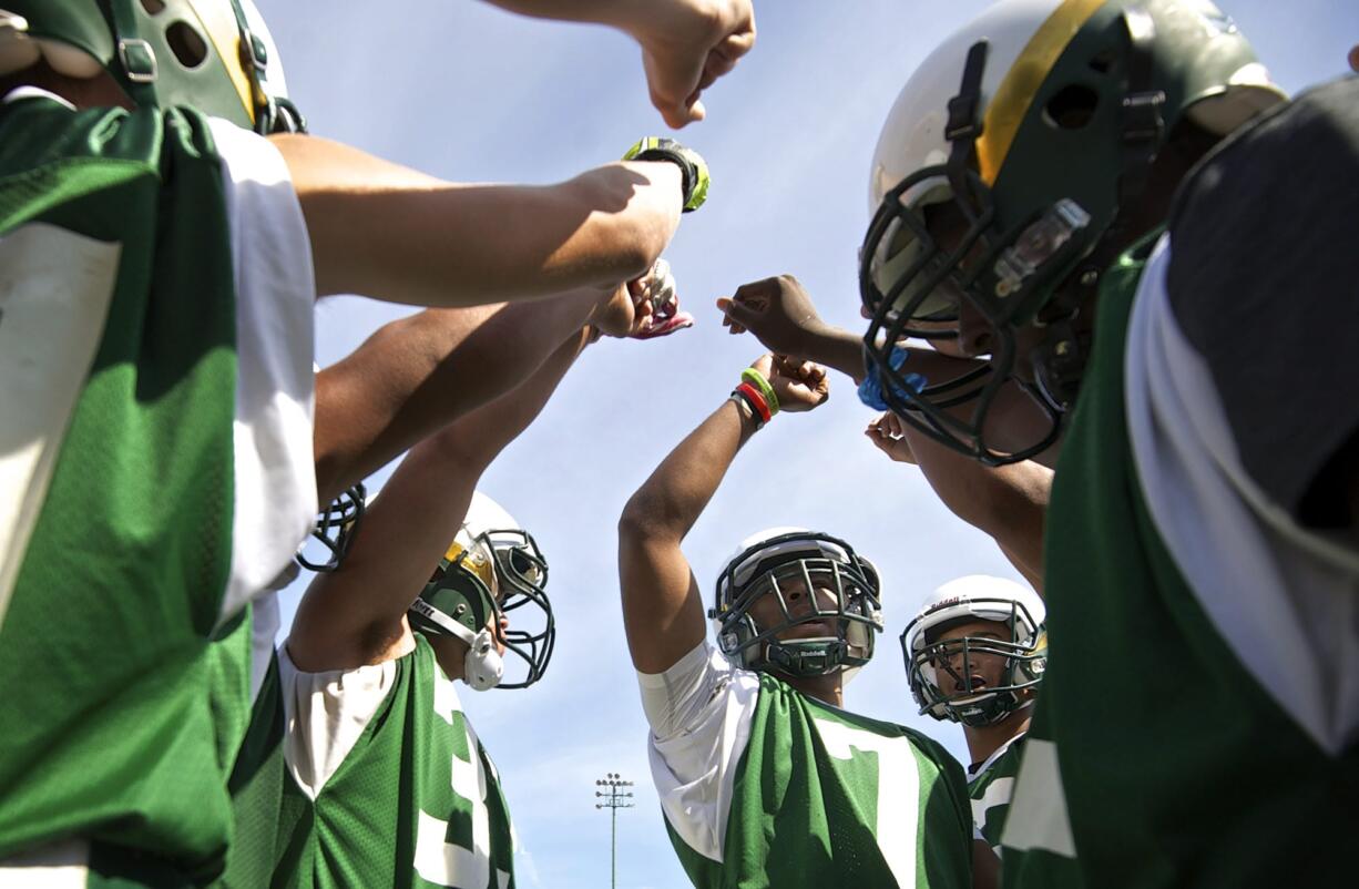 Evergreen's Rey Green, center, huddles with teammates during practice at McKenzie Stadium on Thursday.