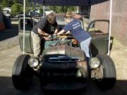 David Hubbard, left, and his wife, Jessica Hubbard, work on their Ford rat rod pickup at their home in Vancouver. Hubbard is expected to drive it 300 miles from St.