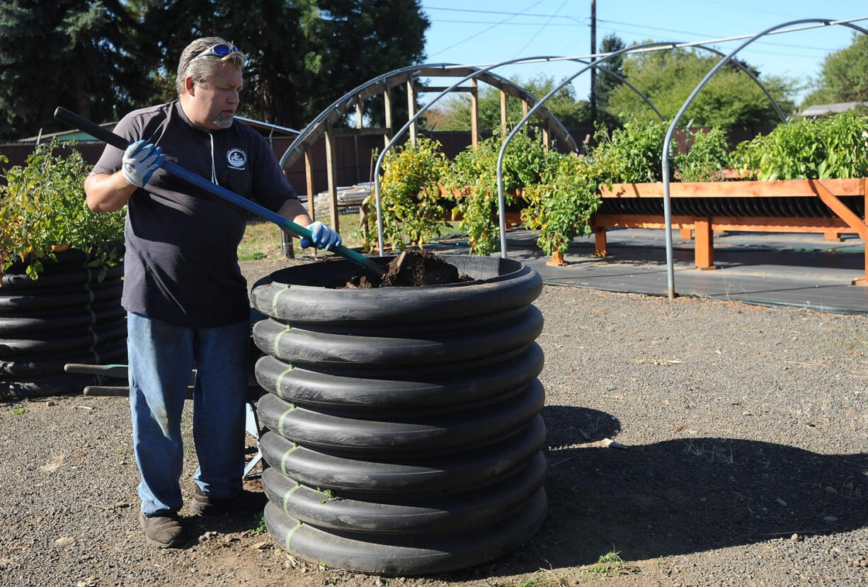 Mike Petersen, Clark County Corrections work crew chief, mixes soil Thursday at the Mabry Center's Veterans Community Garden.