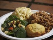 Esoteric BBQ serves up barbecue chicken with cheese shells, corn bread and salad at its downtown Vancouver food cart on June 6.