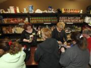 Volunteers Susie Riser, left, and Susan Stoval distribute grocery items to a capacity crowd at the SixEight food pantry in Hazel Dell.