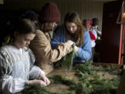 Fort volunteer Margaret Kerby, 11, left, makes wreaths with Emily Winterham, middle, and Camille Shelton on Saturday.