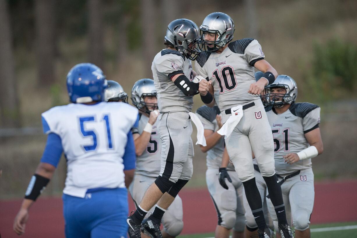 Union High School's Keithen Shepard, center, celebrates with teammates including Jordan Lawson (10) after scoring a touchdown in the first quarter Friday at McKenzie Stadium.(Amanda Cowan/The Columbian)