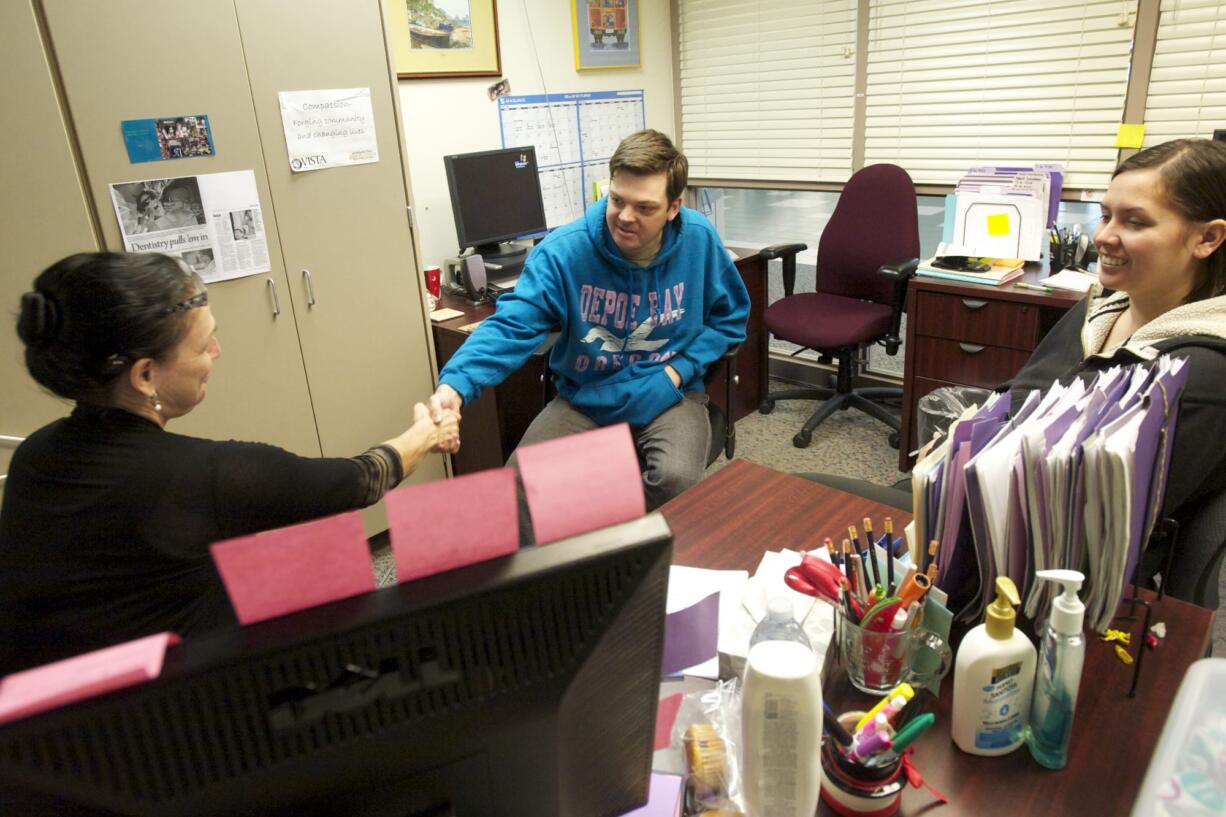 Megan Canton, left, a volunteer at the Free Clinic of Southwest Washington, helps Knute Rockney, 28, sign up for Washington Apple Health, the state's Medicaid program, during an enrollment session at the clinic April 19.