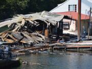 A fire destroyed at least two floating homes at Kadow's Catapiller Island Marina off Lower River Road Sunday night. Workers were trying to rebuild part of the dock, which also burned, Monday afternoon.