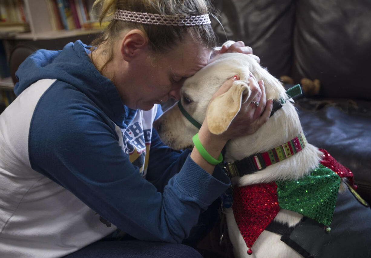 Heidi Anderson snuggles with Limon, a therapy dog, Wednesday at Share Homestead, a family homeless shelter.