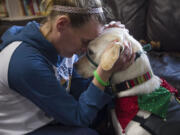 Heidi Anderson snuggles with Limon, a therapy dog, Wednesday at Share Homestead, a family homeless shelter.