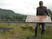 Amateur historian Gene Ritter of Vancouver stands with a newly placed historical marker along Lewis River Road at the Swift Power Canal in Skamania County.