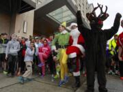 Community members warm up Sunday morning before running or walking to raise money for residents who have been asked to vacate their Courtyard Village Apartments.