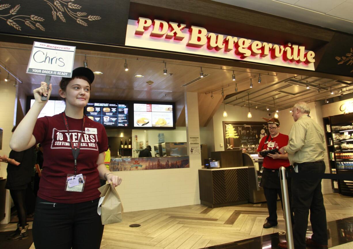 Laurin Radcliffe delivers food at the airport location of Burgerville, near Gate D6.