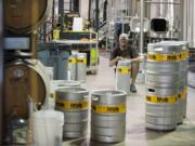 Mark Doleski, center, co-owner of Fortside Brewing Company in Vancouver, prepares half-barrels and sixtel kegs at the brewery, which celebrates its open house Thursday through Saturday.