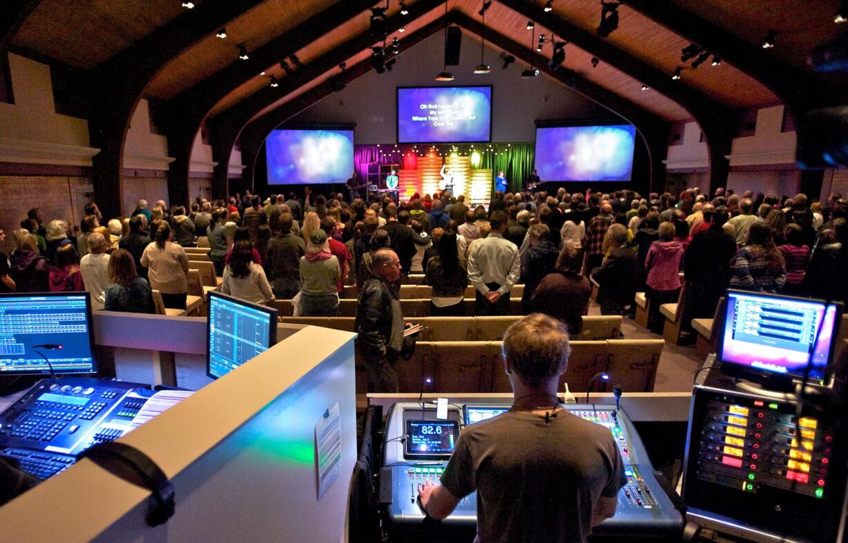 New Heights Church sound engineer Jonathan Dukes, bottom right, works the board during a Saturday evening service in early April.