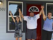 The West family -- daughter Cheyenne, dad Doug, and son Kody -- celebrate on the front porch of their new home Sunday.