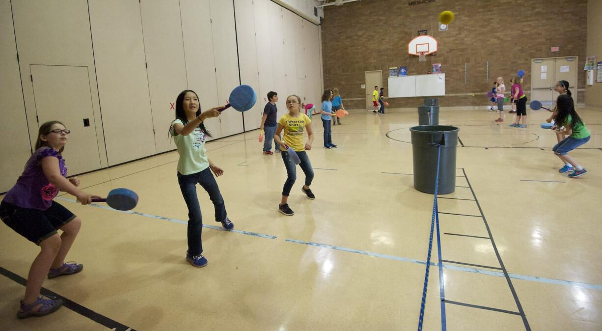 Fourth-graders at Illahee Elementary School play pickle ball in part of the school gym during physical education class.