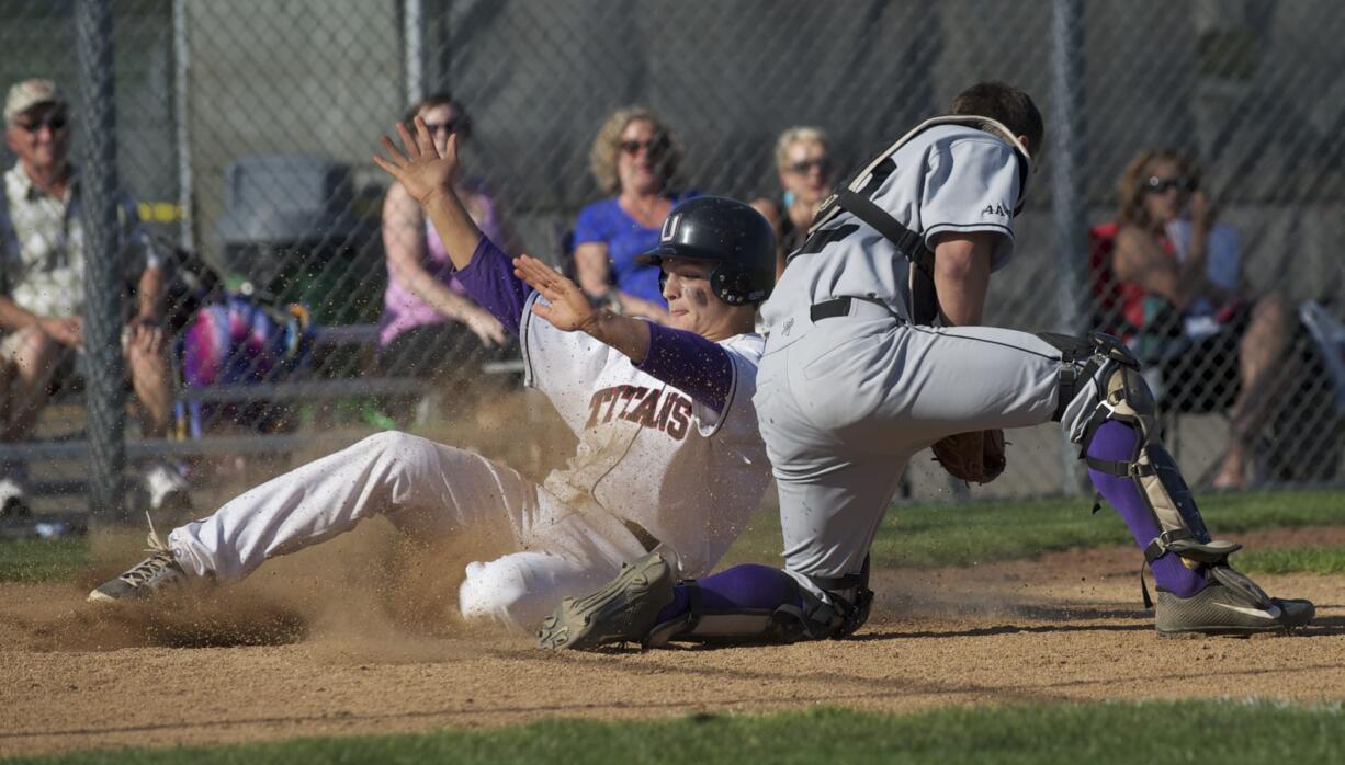 Union base runner Jack Bauer slides past Battle Ground catcher Gunner Talkington to score the game-tying run.