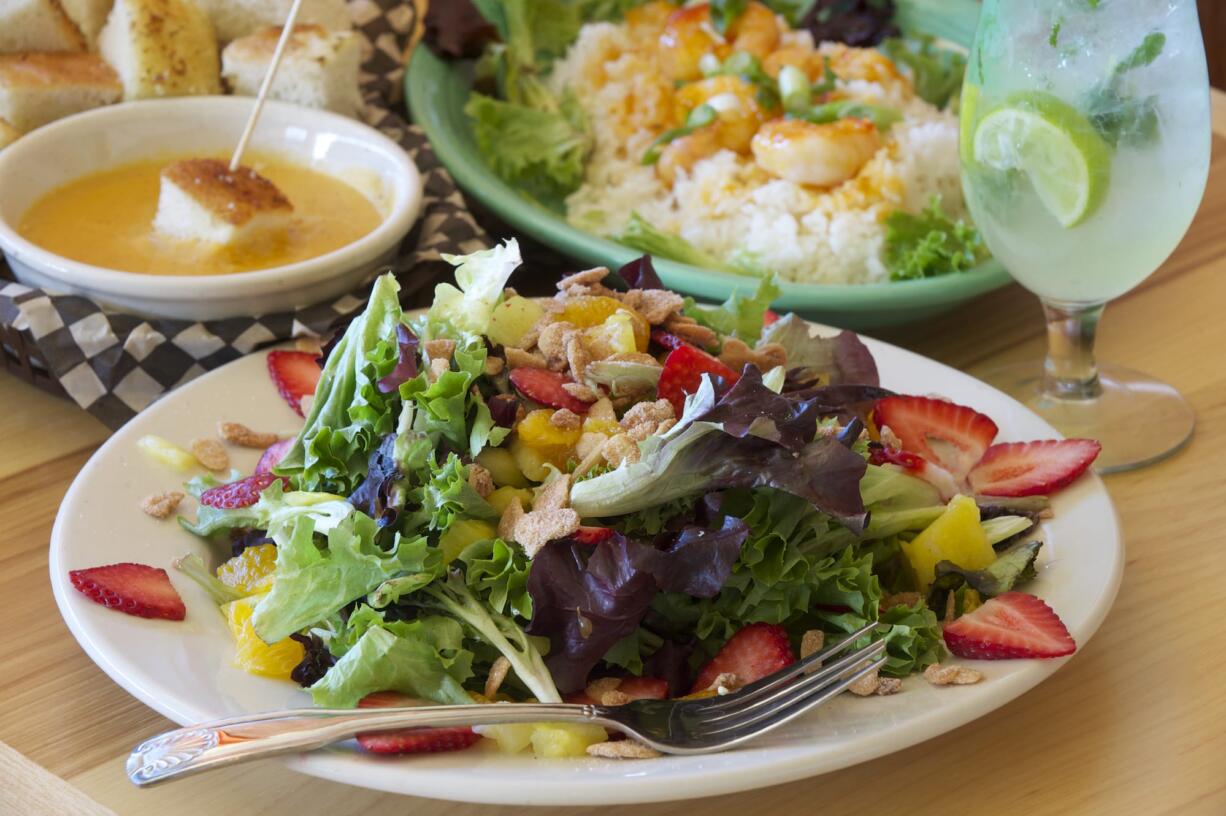 Summertime salad with candied almonds, sauteed prawn rice bowl with ginger chili sauce, and basic fondue at South Pacific Cafe &amp; Lounge, photographed Jan.