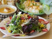 Summertime salad with candied almonds, sauteed prawn rice bowl with ginger chili sauce, and basic fondue at South Pacific Cafe &amp; Lounge, photographed Jan.