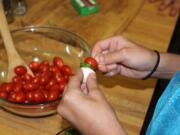 Jennifer Jorgensen
A Sunset Elementary School fifth-grader makes a salad skewer at a book release party Tuesday for &quot;The Cultured Chef: An International Cookbook for Kids.&quot; Teacher Rachelle Matheson helped create the book.