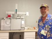 Dana Luce, owner of GOAT Labs, stands next to some of his testing equipment.