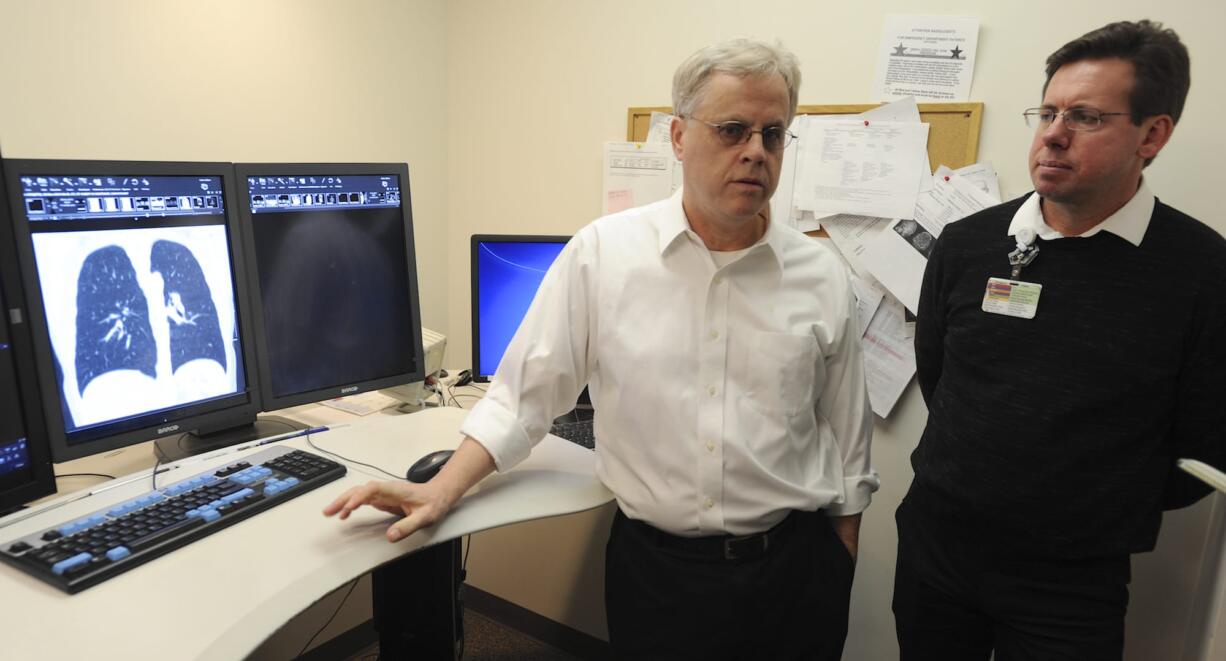 Radiologist William Kuhle, left, and Dr. Michael Myers, a radiation oncologist, discuss a new lung cancer screening program to roll out next month at PeaceHealth Southwest Medical Center in Vancouver. The program will follow the first lung cancer screening recommendations implemented in the U.S.