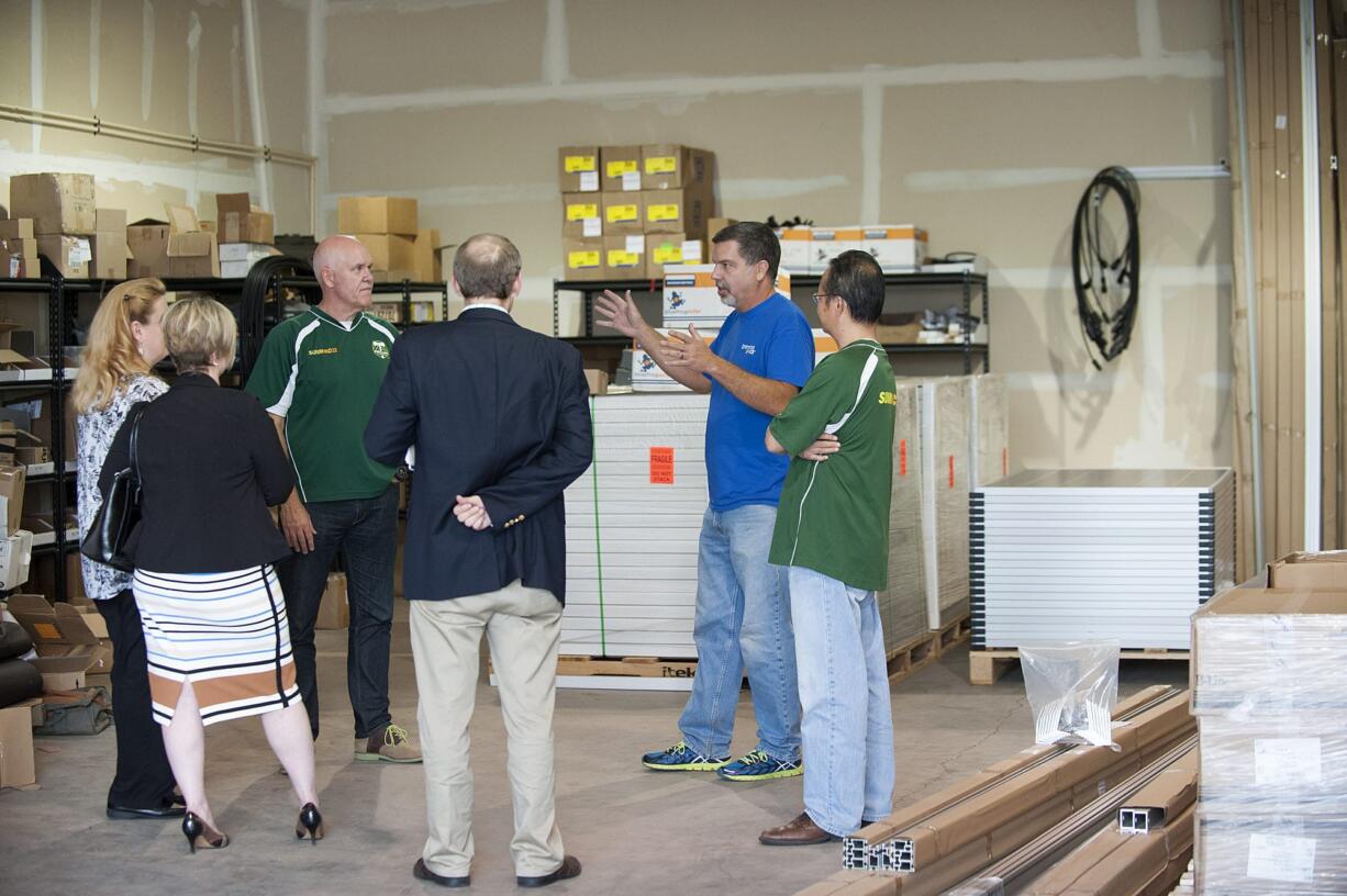 Rick Campfield of SunModo, third from left, and John Harley of Brimma Solar, second from right, talk about the future of solar energy Thursday afternoon, Sept. 3, 2015 at Brimma Solar in Vancouver.