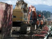 Construction crews from Rotschy Inc. work to expand the road along Northeast 119th Street near the intersection with Northeast 72nd Avenue on Friday morning, Sept. 18, 2015.