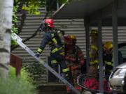 Vancouver firefighters prepare to recover a body from an apartment complex on Thursday in Vancouver after an early-morning fire.