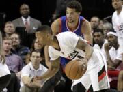 Portland Trail Blazers guard Damian Lillard, left, drives past Philadelphia 76ers guard Michael Carter-Williams during the first half Friday, Dec. 26, 2014.