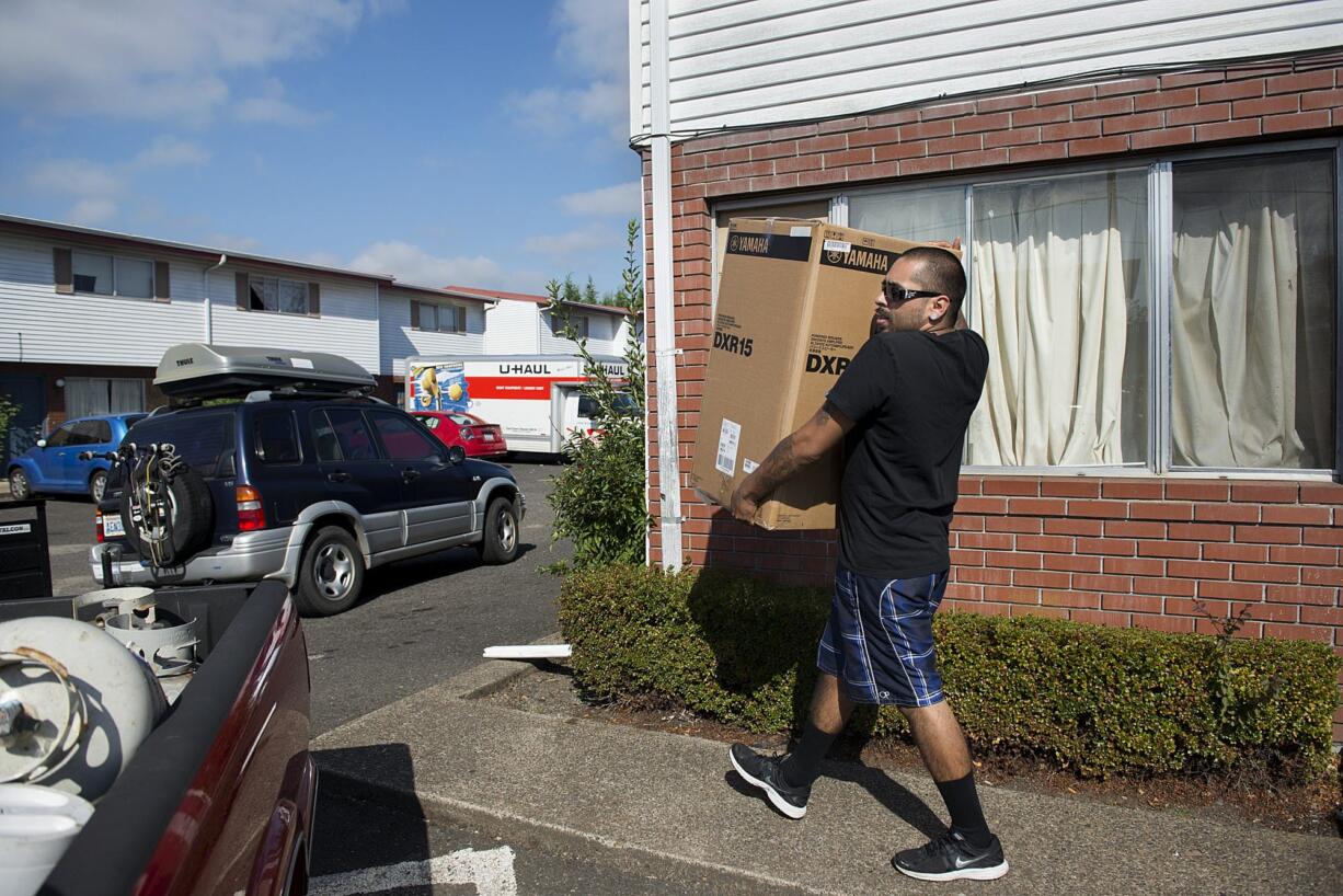 Victor Estrada, who has lived at Ghim Village for 16 years, loads moving boxes into a waiting pickup Wednesday.