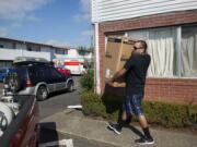 Victor Estrada, who has lived at Ghim Village for 16 years, loads moving boxes into a waiting pickup Wednesday.