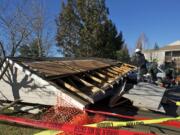 Crews clean up after wind toppled a carport at the Eight Towncenter at Fisher's Landing apartments on Friday.