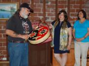 Arnada: Sam Robinson, left, vice chairman of the Chinook Nation, offers a traditional blessing for outgoing Clark County Historical Museum Executive Director Susan Tissot, center, during her farewell party on May 13.