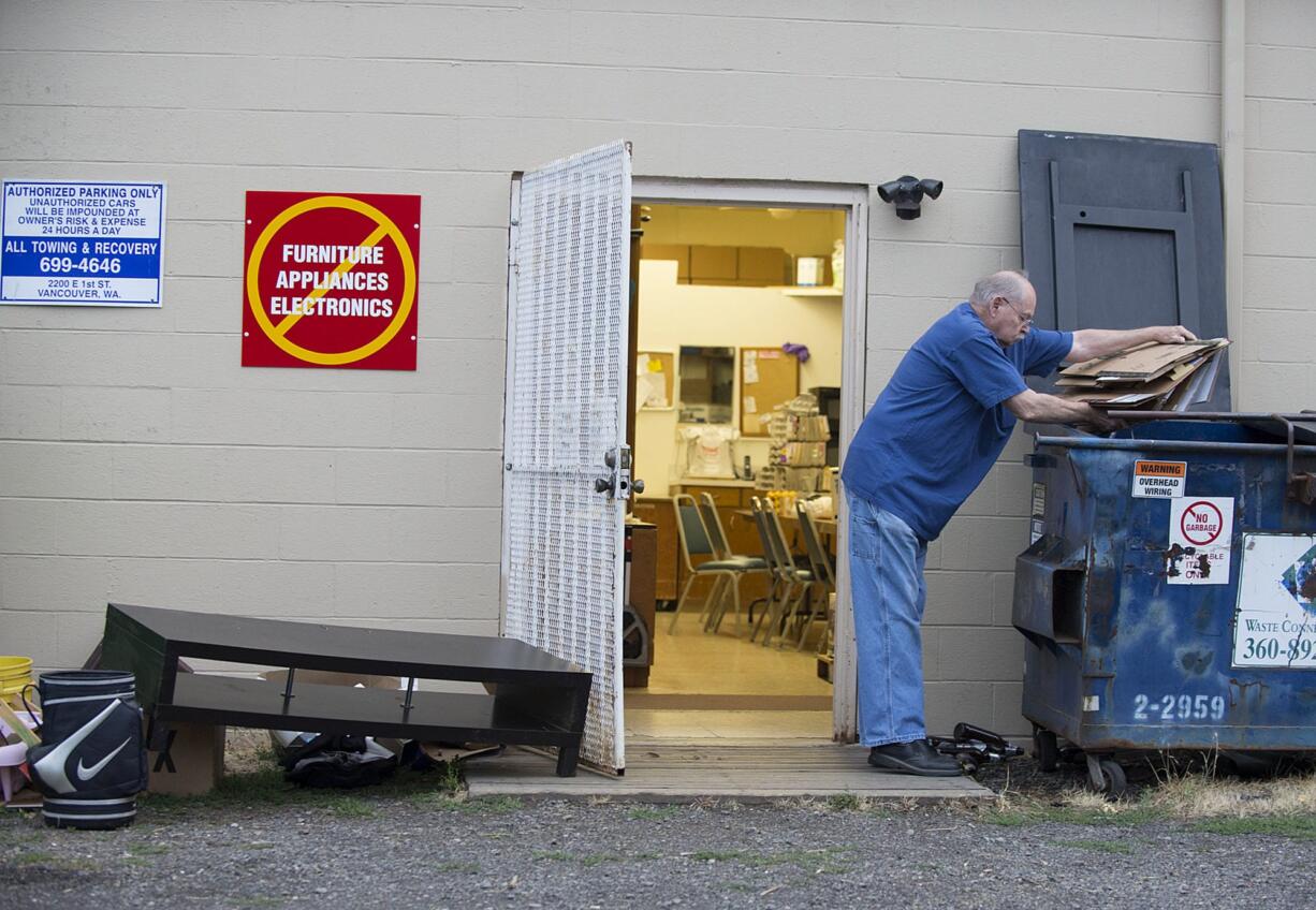 Norm Wilmot, a volunteer for Clark County Adventist Community Services, recycles cardboard after finding a pile of rubbish outside the organization’s door the morning of Aug. 31.