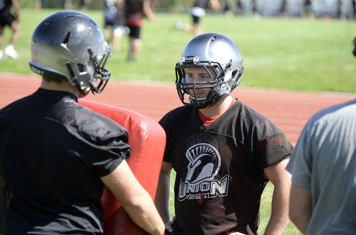 Union High School's Zach Berfanger, center, stays focused as he battles teammates during practice Wednesday afternoon, August 19, 2015, at the team's practice field.