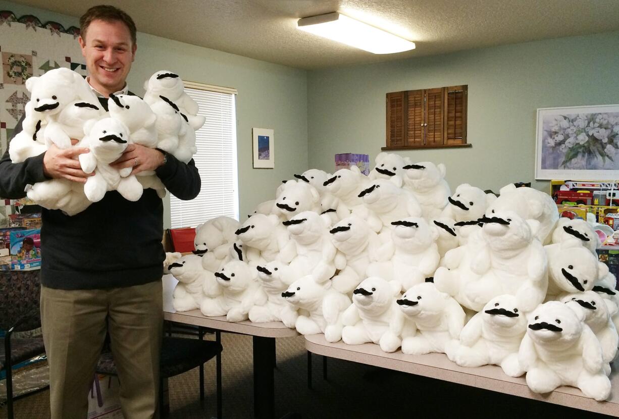 Vancouver: iQ Credit Union Development Director Matthew Butte holds mustached and stuffed polar bears that were collected for charities during the credit union's recent &quot;Get a Loan, Give Some Love&quot; promotion.