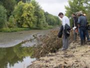 John Tyler of the Bonneville Power Administration, left, checks out the Buckmire Slough at the northern most barrier while joined by Tom Josephson of Columbia River Estuary Study Taskforce, second from left, on Friday.(Amanda Cowan/The Columbian )