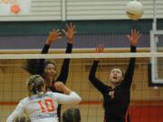 Battle Ground High School's  Ashley Watkins (C) and Kimberly Lasley (R) defend the net against Ridgefield's Madi Harter (L) at a volleyball in Battle Ground Thursday September 10, 2015.