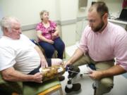 Mark Sauser, from Evergreen Prosthetics and Orthotics, makes adjustments Aug.