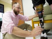 Mark Sauser, from Evergreen Prosthetics and Orthotics, makes adjustments to Earl Davidson's new prosthetic leg, Aug.