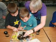 Yacolt: Washington State University master gardener volunteer Maureen Humbert helps first-graders at Yacolt Primary School look through compost for worms in April.