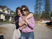 Tiffany Johnson, left, embraces her longtime friend Shelly Johnson at the site of Shelly and her husband, Craig’s, new home. Tiffany Johnson created a nonprofit group, Raise the Roof Foundation, to raise money to build the Johnsons a new home.