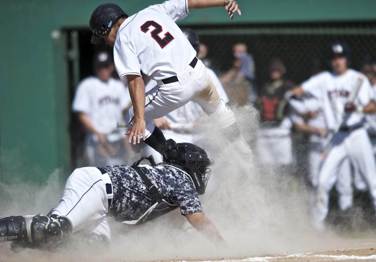 Union's Ethan Beniga jumps over Todd Beamer's catcher Kepa Sharpe to open the scoring in the first inning in a 4A bi-district playoff game.