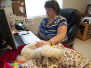 Tami Marshall has her dog Jazzy to keep her company during her workday at home. Marhsall is a medical coding specialist for Vancouver-based PeaceHealth, which allows its coders to work from home.