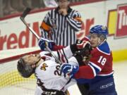 The Winterhawks' Brendan Leipsic takes a stick up high from the Oil Kings' Reid Petryk in the second period.