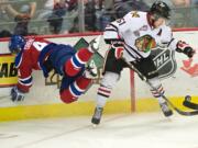 The Winterhawks' Derrick Pouliot checks the Oil Kings' Blake Orban off the puck in the second period of game 7 of the WHL finals at the Veterans Memorial Coliseum on Monday May 12, 2014.