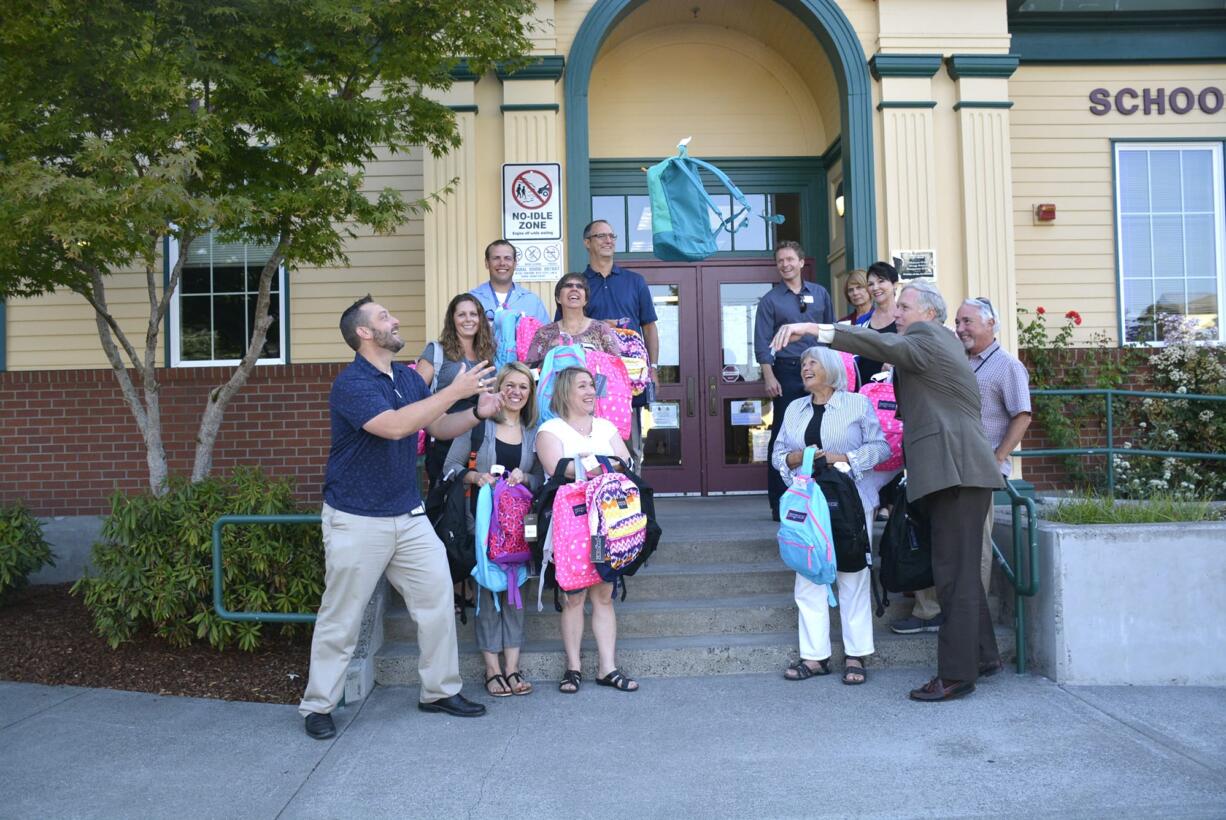 Camas: Members of the Camas-Washougal Rotary Club deliver backpacks filled with school supplies to Hathaway Elementary School.