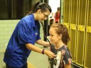 Central Park: PeaceHealth family medicine resident Lisa Cuneo examines 13-year-old volleyball and track athlete Jasmine Monagon.